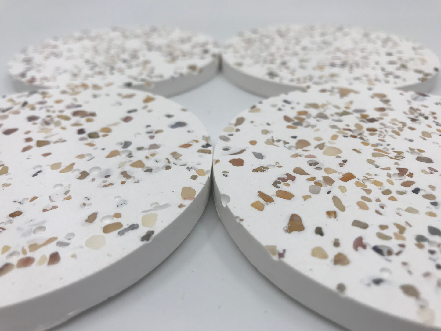 Terrazzo-style circular coasters on a white background