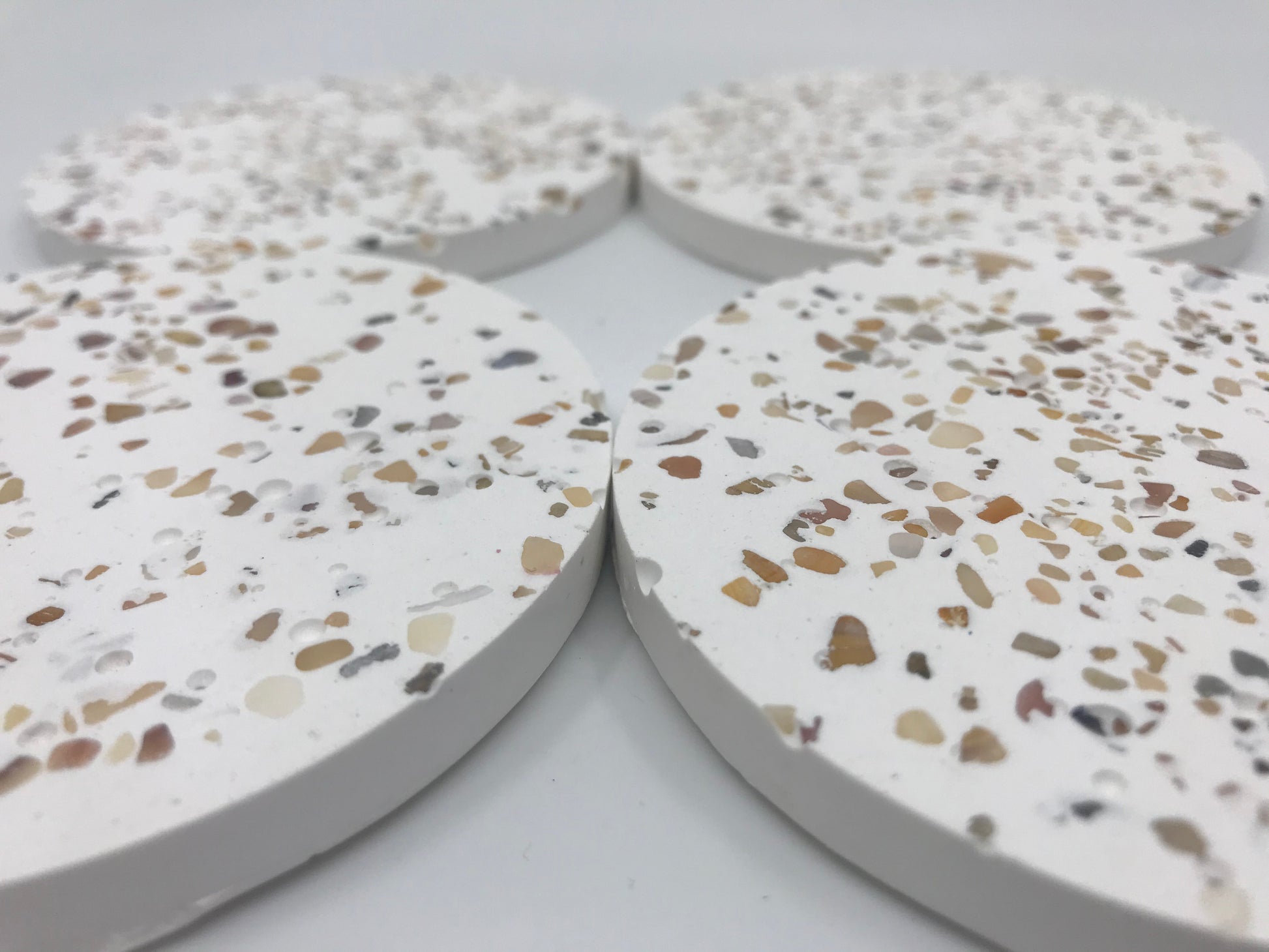 Terrazzo-style circular coasters on a white background